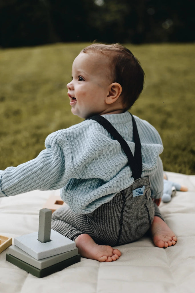 Un bébé habillé chaudement avec son chandail couleur glace