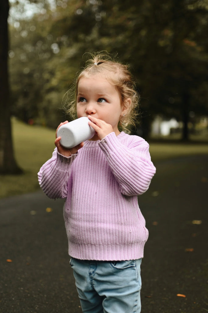 un joli chandail en tricot couleur lavande porté par une petite fille