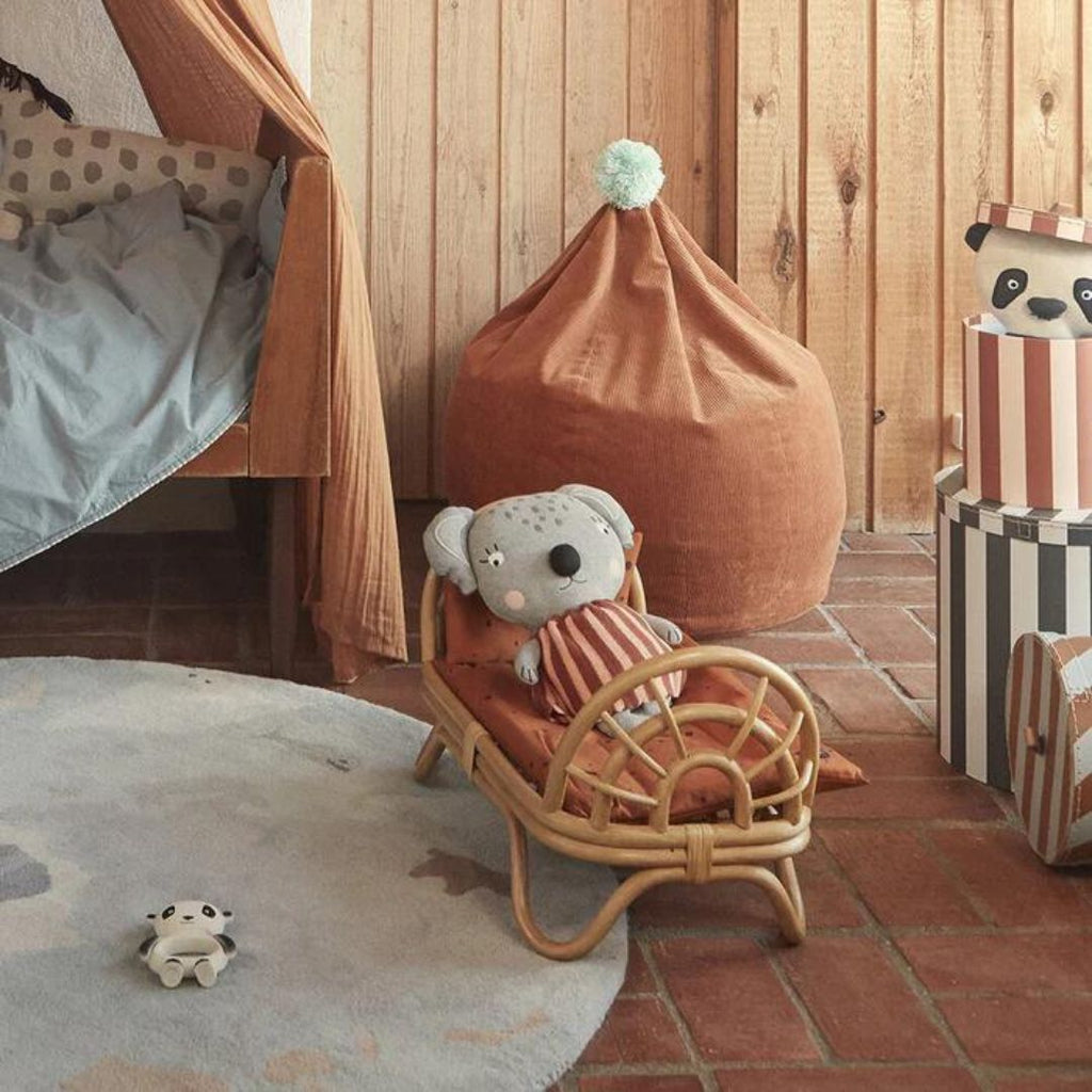 Chambre d'enfant avec des jouets de chez Oyoy living design et un lit de poupée en rotin