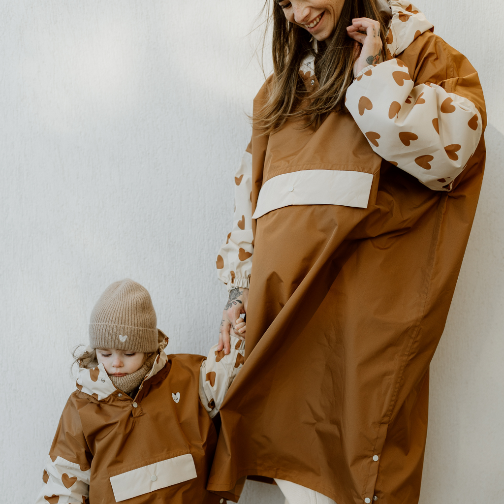 Une maman et sa fille portant le poncho de pluie de la marque Poule Party