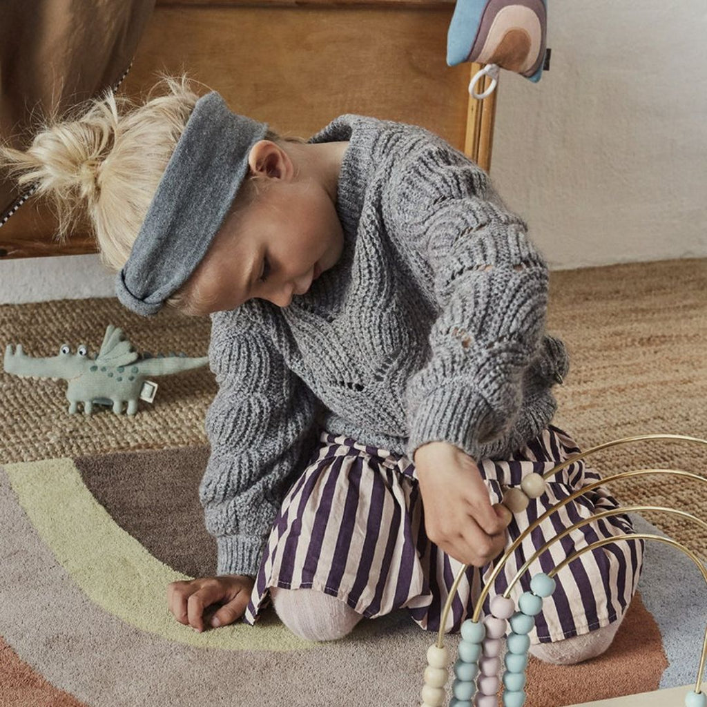 Petite fille blonde qui joue avec le hochet en coton crocodile de chez Oyoy living design